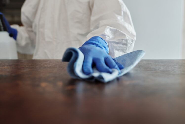 man wiping table with cloth
